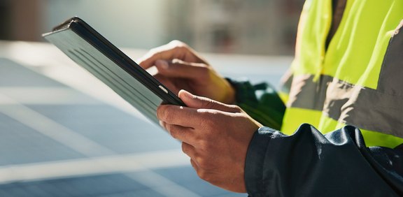 Techniker mit Tablet an einer Solaranlage